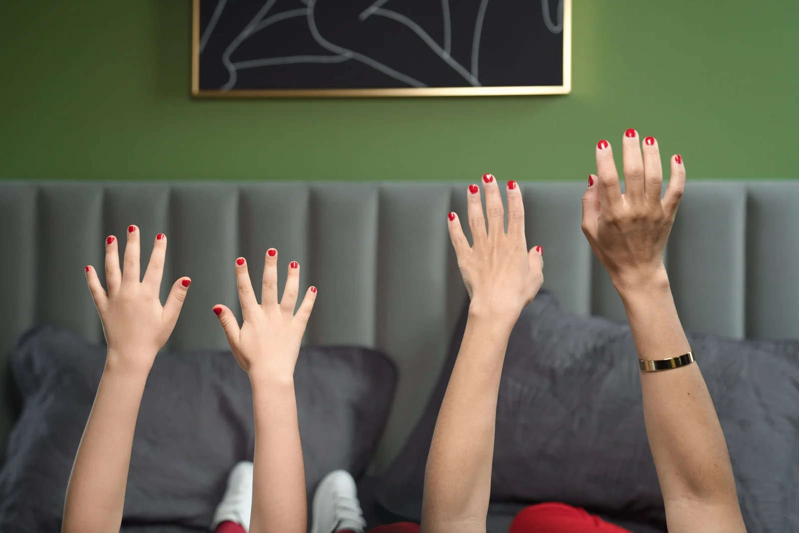 Plusieurs mains d'enfant aux ongles courts vernis, posées côte à côte