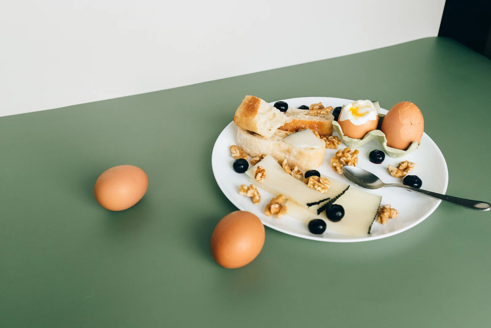 Petit-déjeuner associant œufs, yaourt, pain complet et oléagineux